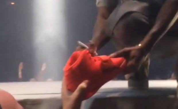 Kanye West Signs a Pair of Red October Yeezy 2s During Concert