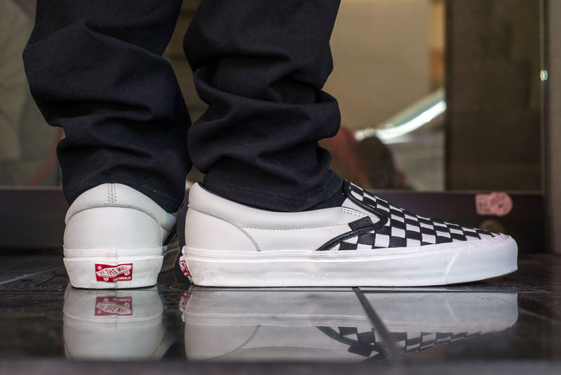 vans slip on all black on feet