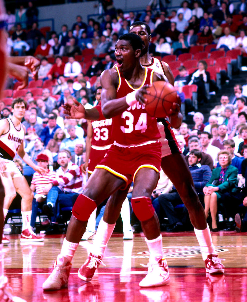 PORTLAND, OR - 1987: Hakeem Olajuwon #33 of the Houston Rockets handles the ball against the Portland Trail Blazers during a game played circa 1987 at the Veterans Memorial Coliseum in Portland, Oregon. NOTE TO USER: User expressly acknowledges and agrees that, by downloading and or using this photograph, User is consenting to the terms and conditions of the Getty Images License Agreement. Mandatory Copyright Notice: Copyright 1987 NBAE (Photo by Brian Drake/NBAE via Getty Images)