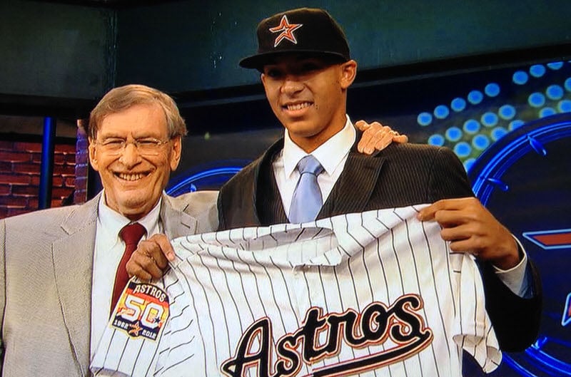 Carlos Correa holding Houston Astros jersey after being drafted