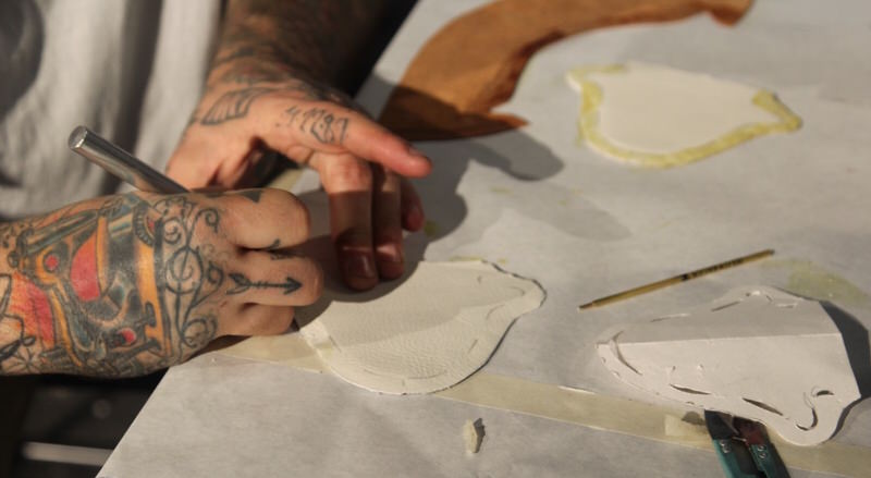 Dominic helping a student cut their leather out