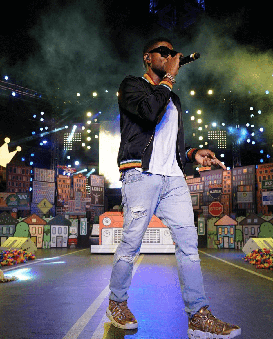 Usher uses the Supreme x Nike Air More Uptempo to match the hues on his bombers jacket.