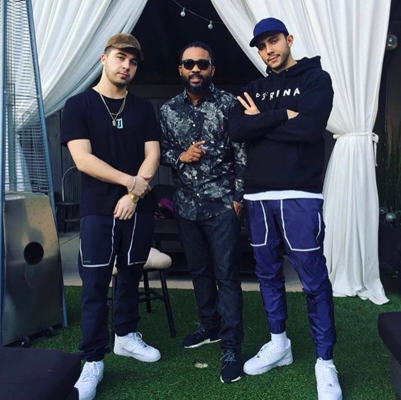 Majid Jordan balancing out their technical pant choice with basic tees, hoodies, and all-white AF1s.