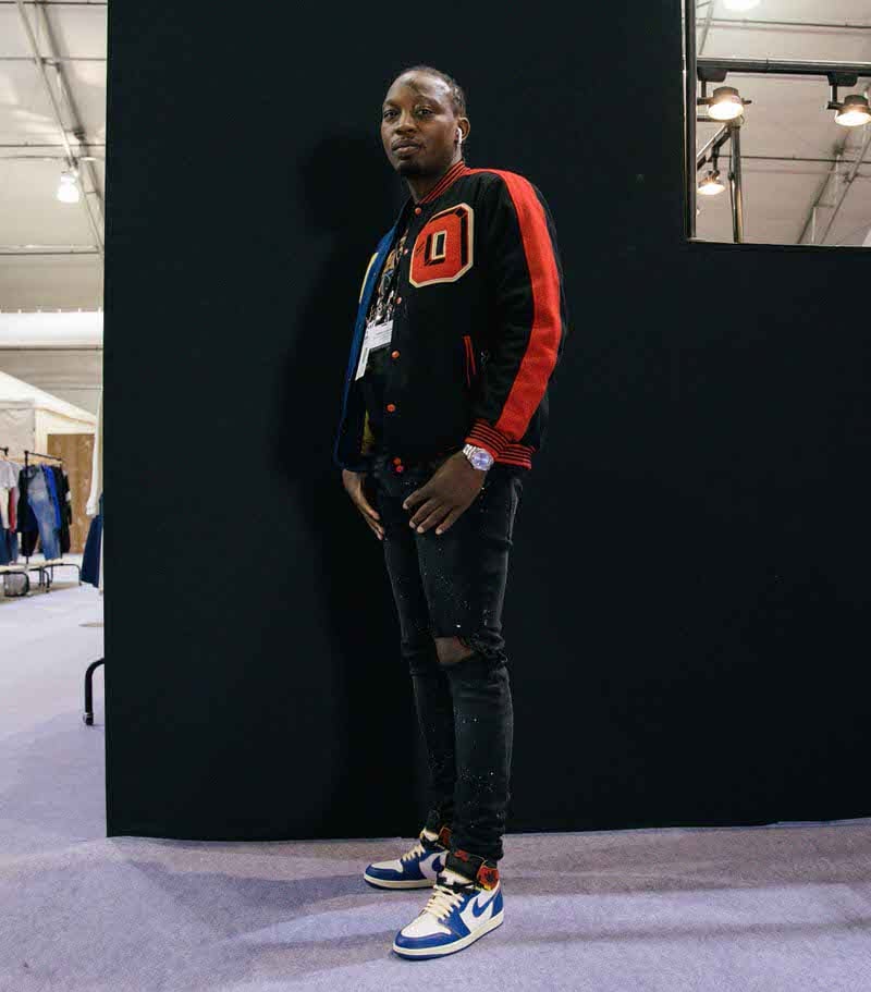 Color coordinating black skinny jeans, a letterman jacket, and a graphic tee with the Union x Air Jordan 1.