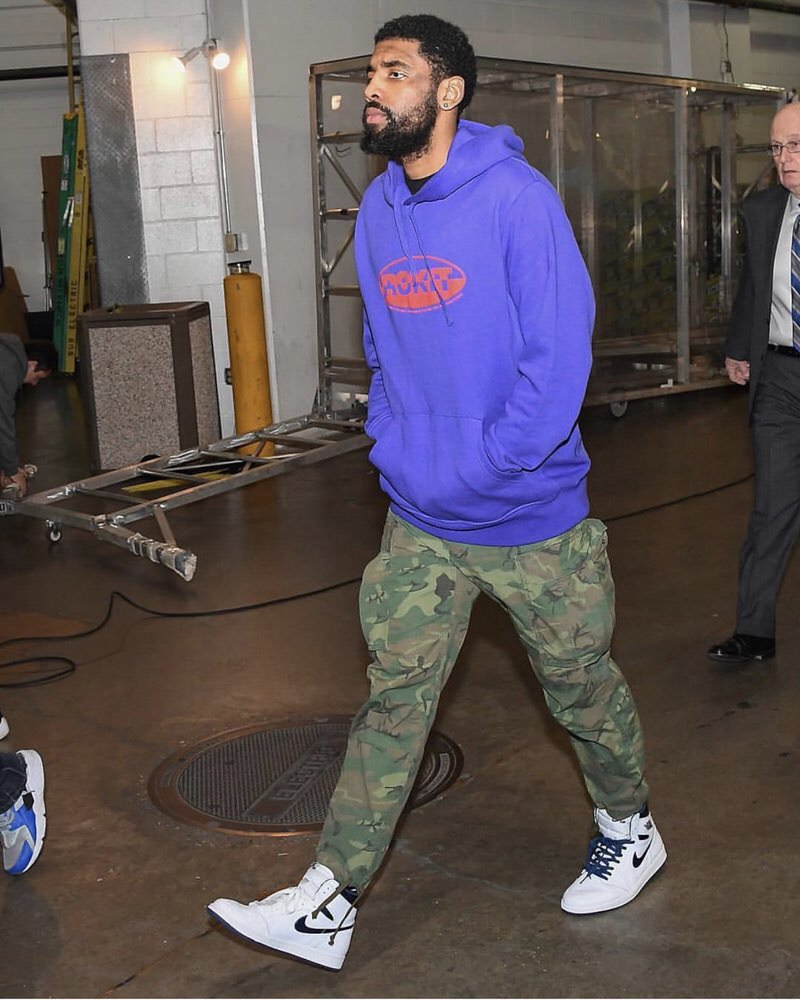 Kyrie pairs a retro inspired Rockit hoodie with Jordan 1s and cargo pants.