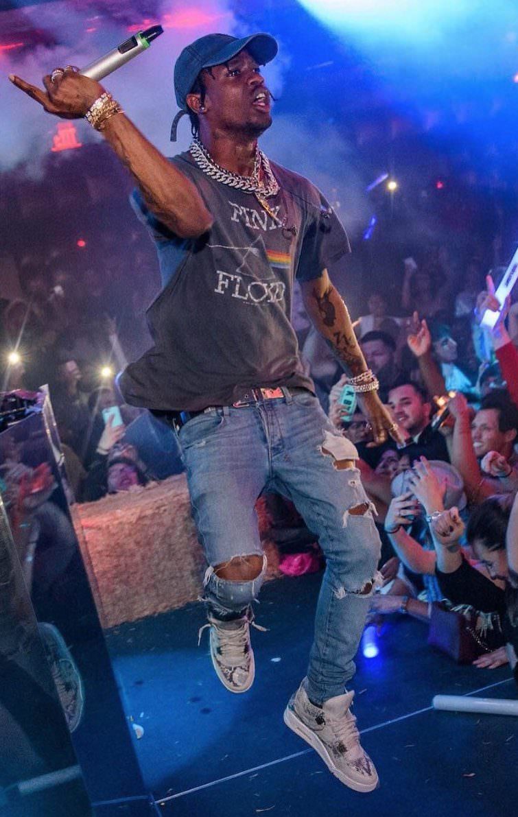 Thrashed jeans and a vintage band tee with Jordan 4s. Travis Scott has grunge style down to a T.